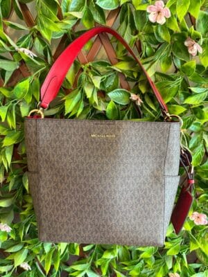 Cartera Michael Kors original, nueva. Diseño monograma MK en tono café con detalles y correa en rojo